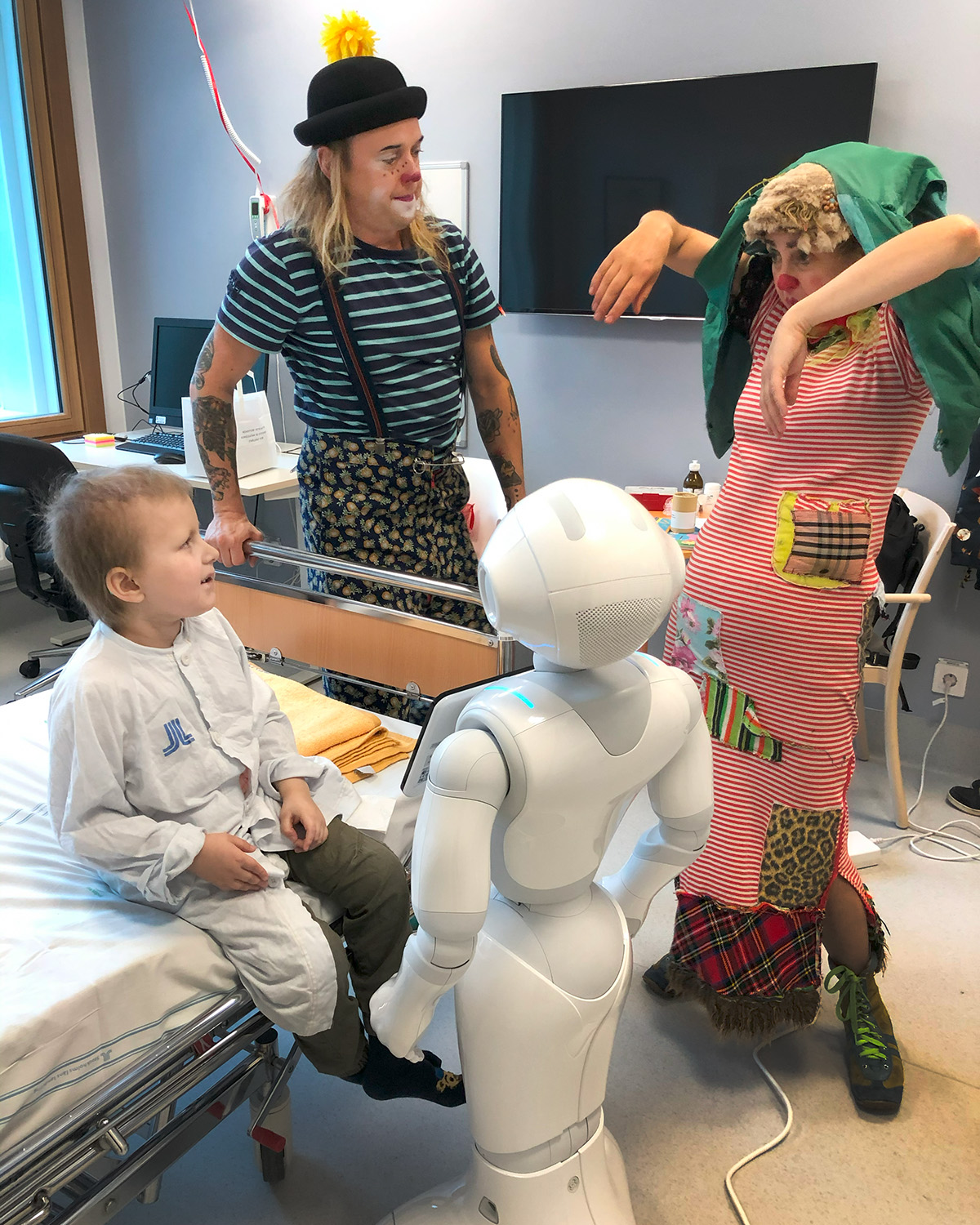 Två clowner underhåller Elis och roboten står bredvid