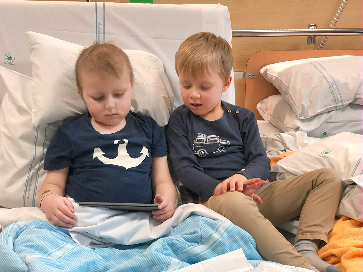 Elis och Folke sitter med iPaden i sängen