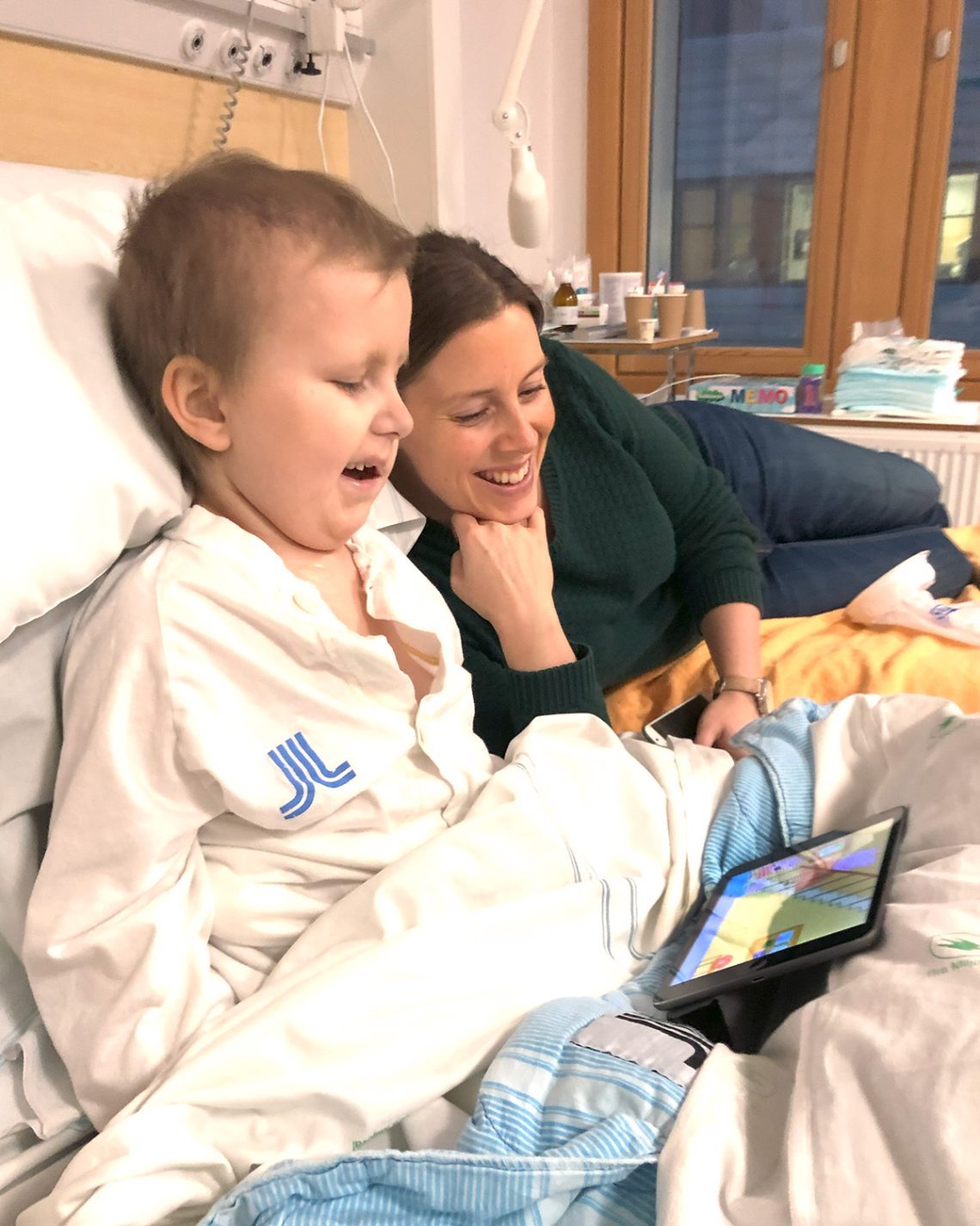 Elis skrattar tillsammans med mamma när de tittar på iPaden.