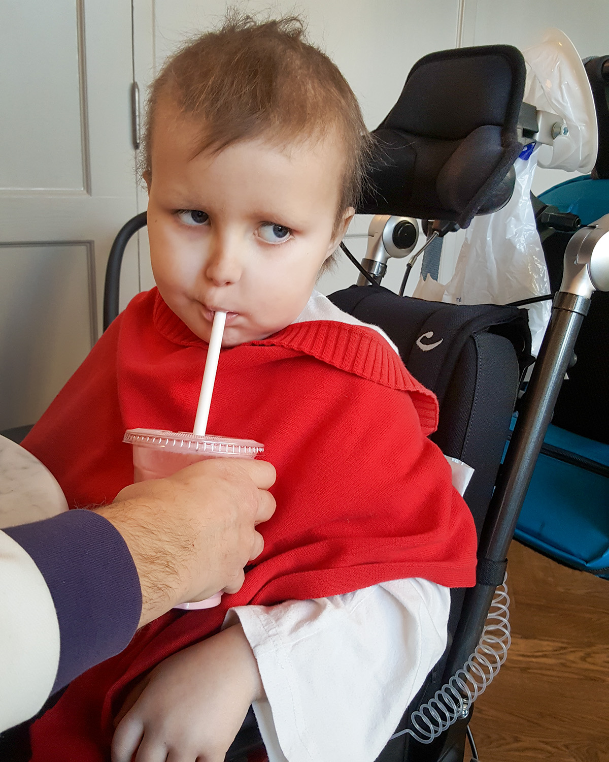 Elis dricker smoothie med sugrör inne på cafét på sjukhuset