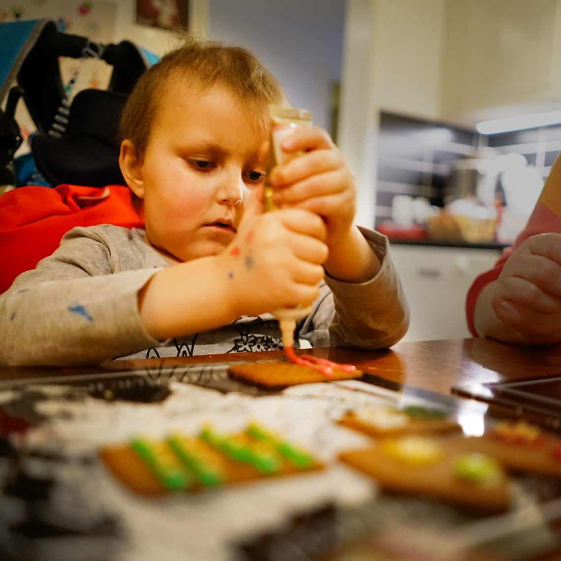 Elis klämmer ut kristyr på sitt pepparkakshus.