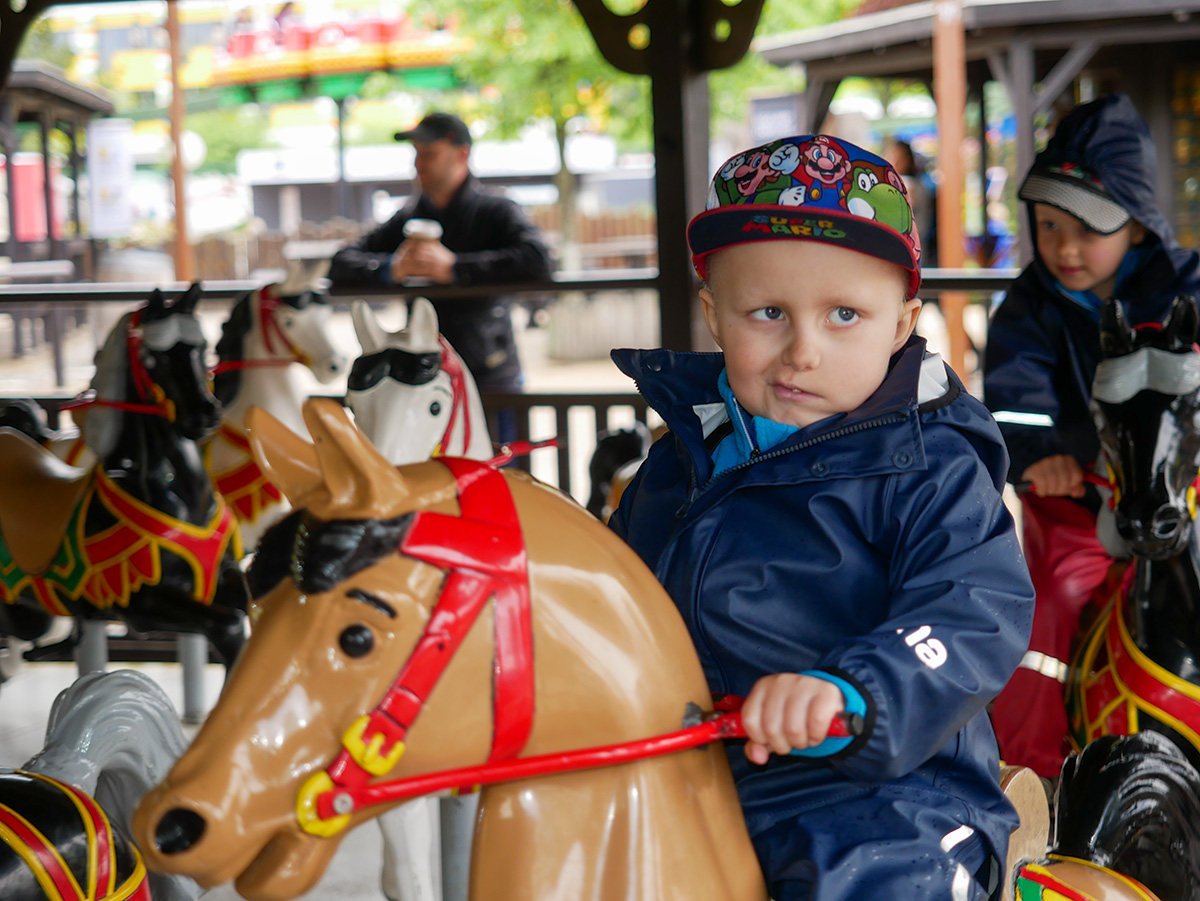 Elis rider på en häst i västernkarusellen.
