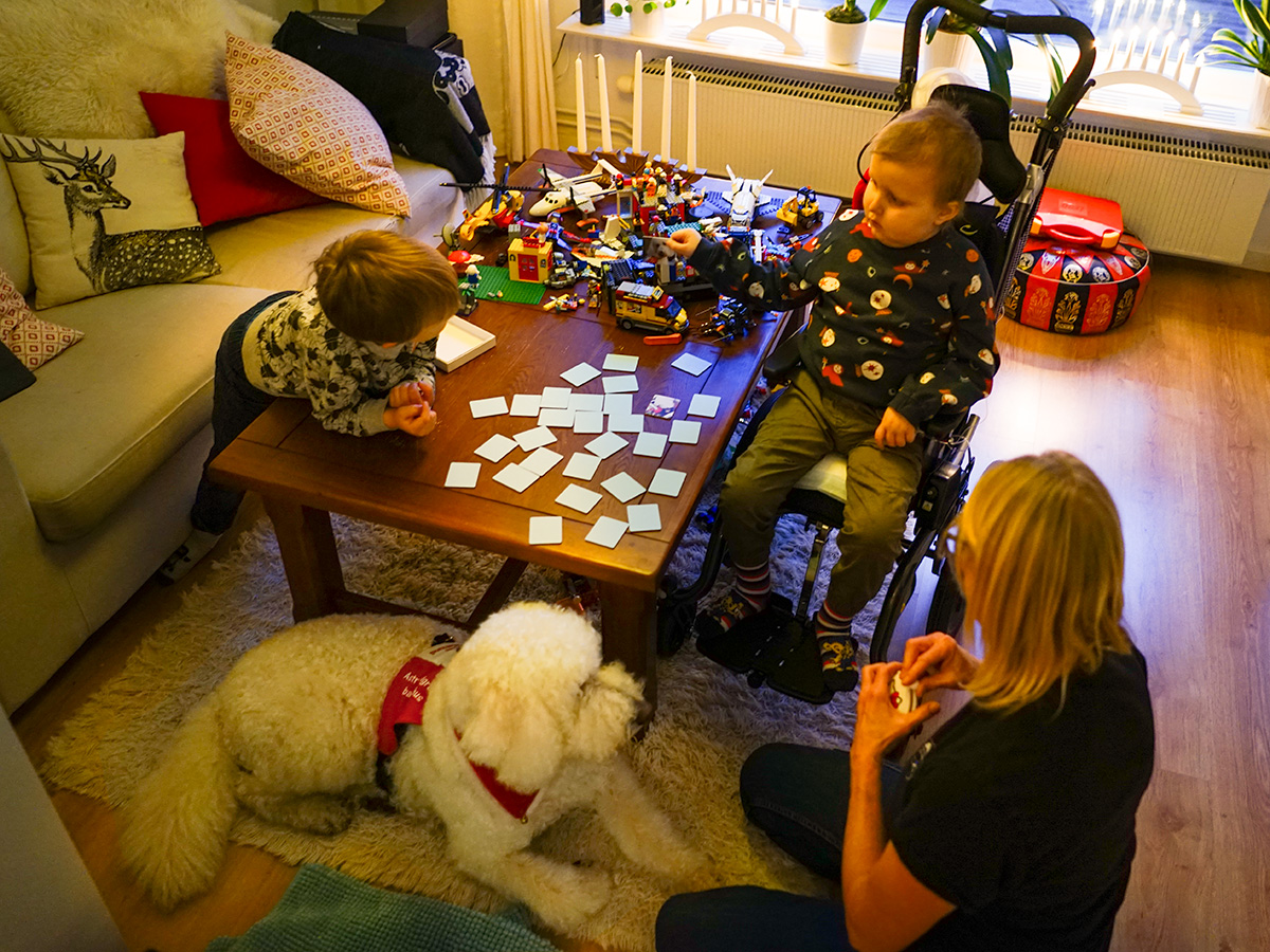Folke och Elis vid soffbordet som är fullt av memorybrickor och lego.