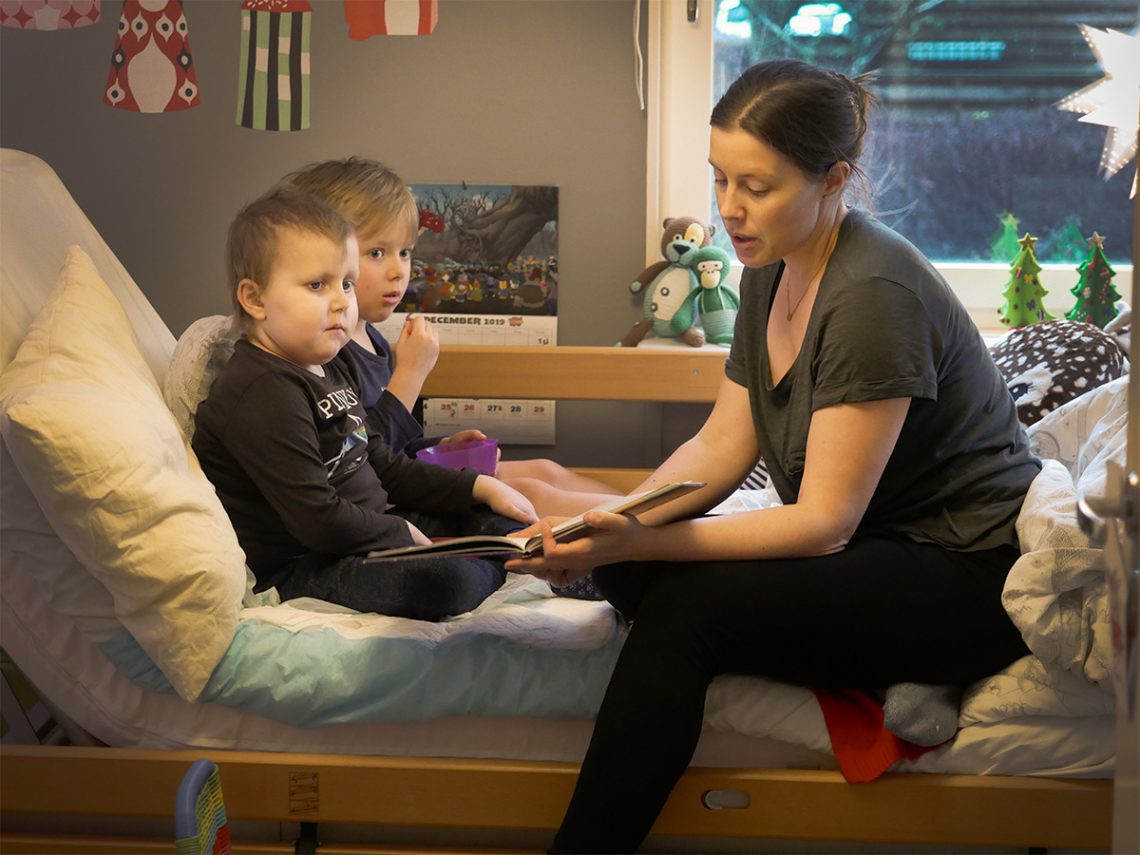 Elis, Folke och mamma läser saga i Elis säng