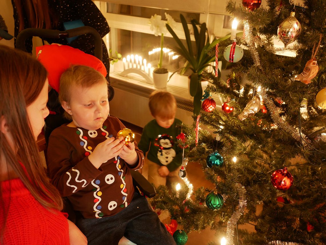 Lilly, Elis och Folke klär granen.