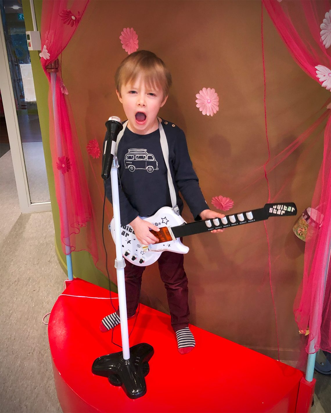 Folke leker med en elgitarr på en liten scen