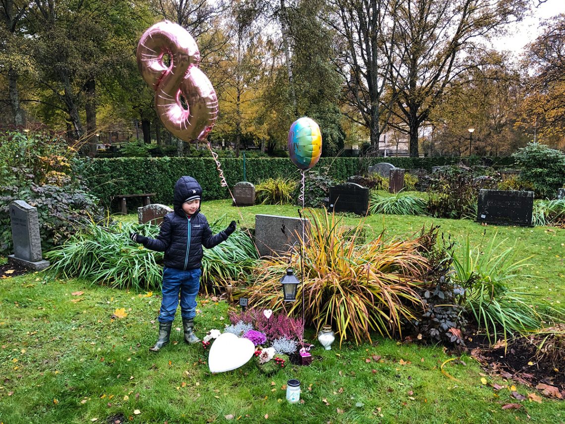 Folke på Elis grav med födelsedagsballonger