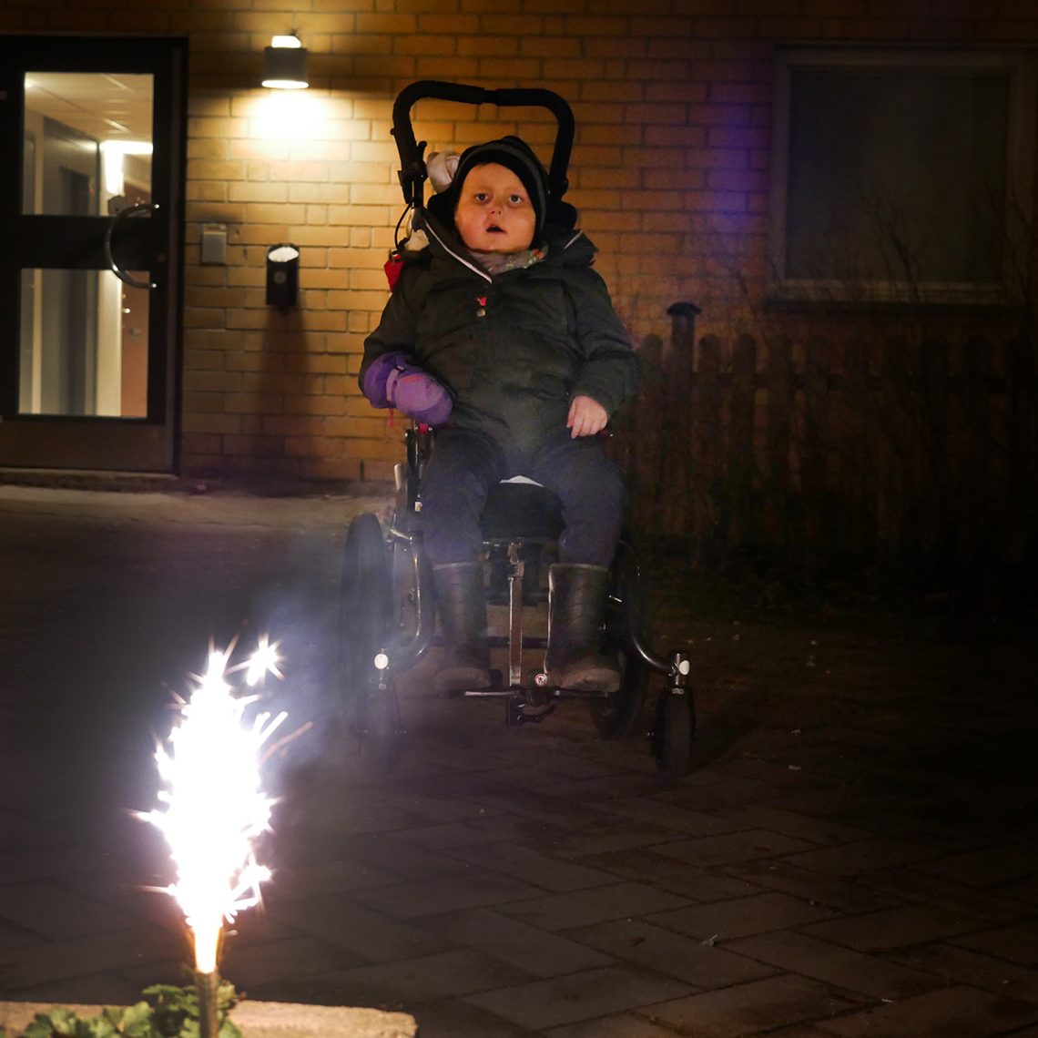 Elis i rullstolen utomhus tittande på en isfackla