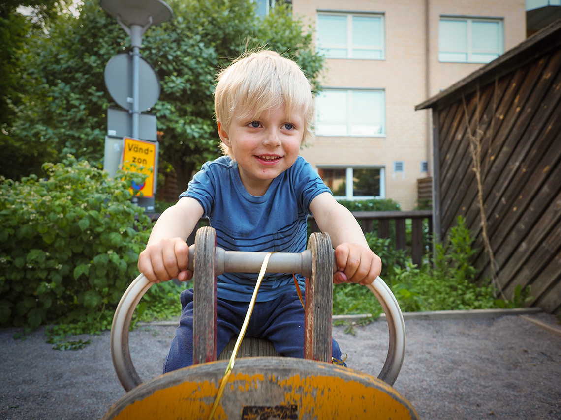 Elis sitter på förskolans gungcykel, hans favoritplats under uteleken.