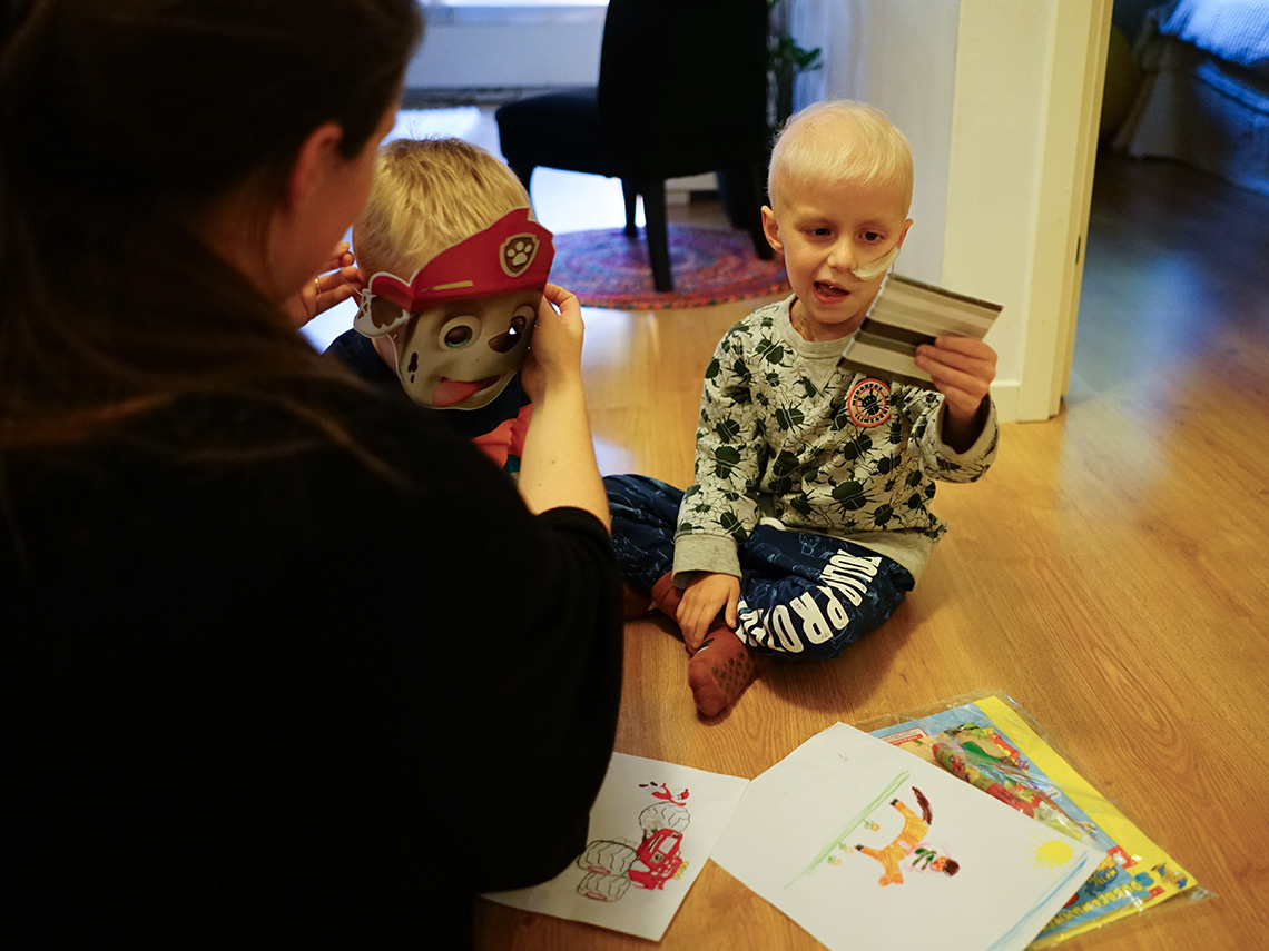 Elis, med slang i näsan, är glad över presenter och teckningar han fått. Folke testar en Paw Patrol-mask bredvid honom.
